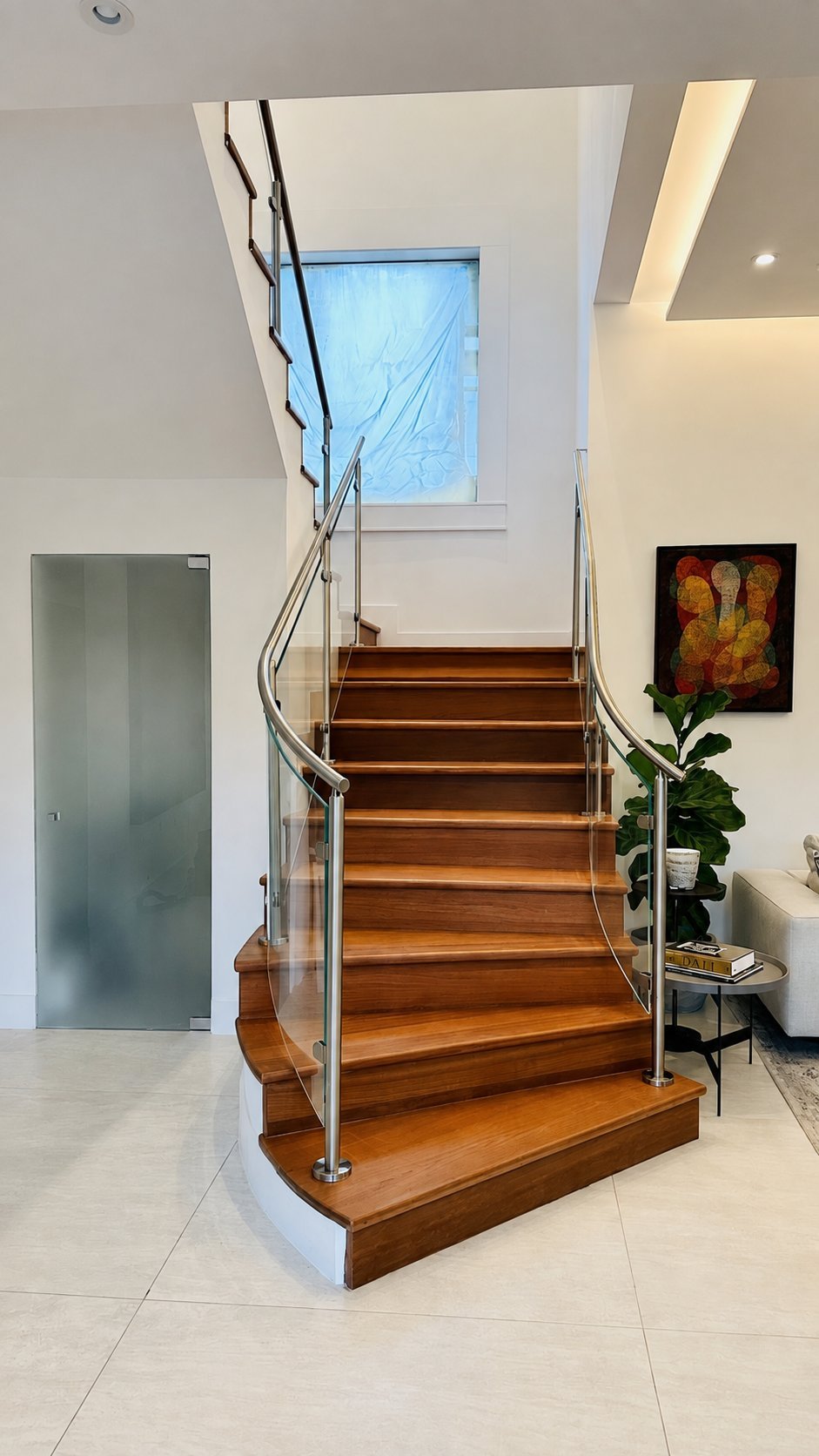 Curved wood staircase with stainless steel and glass railing